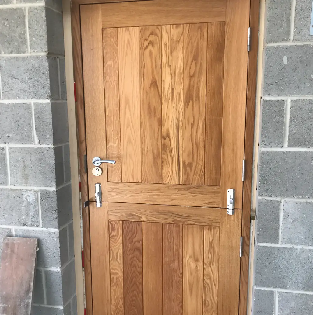 Solid oak ledged door hung in a blockwork opening during fit-out