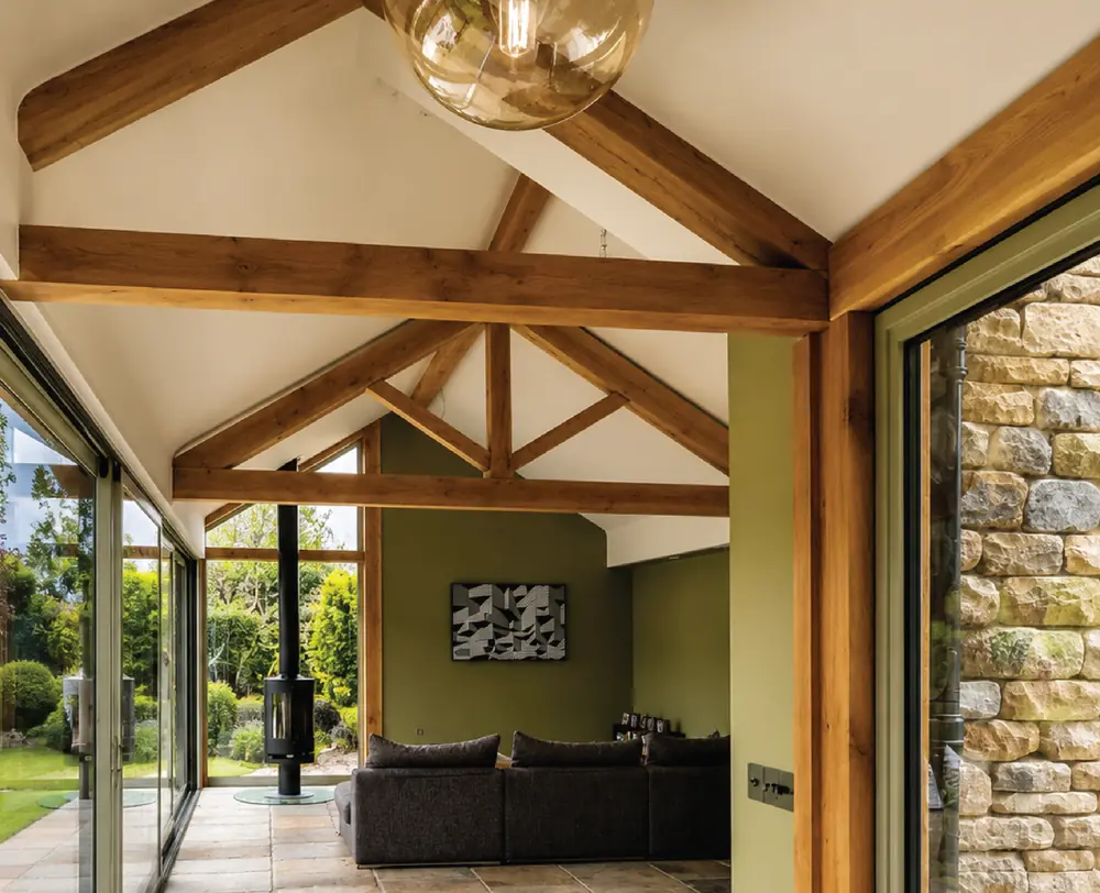 Oak-framed garden room with an exposed king post truss and bi-fold doors opening to the garden