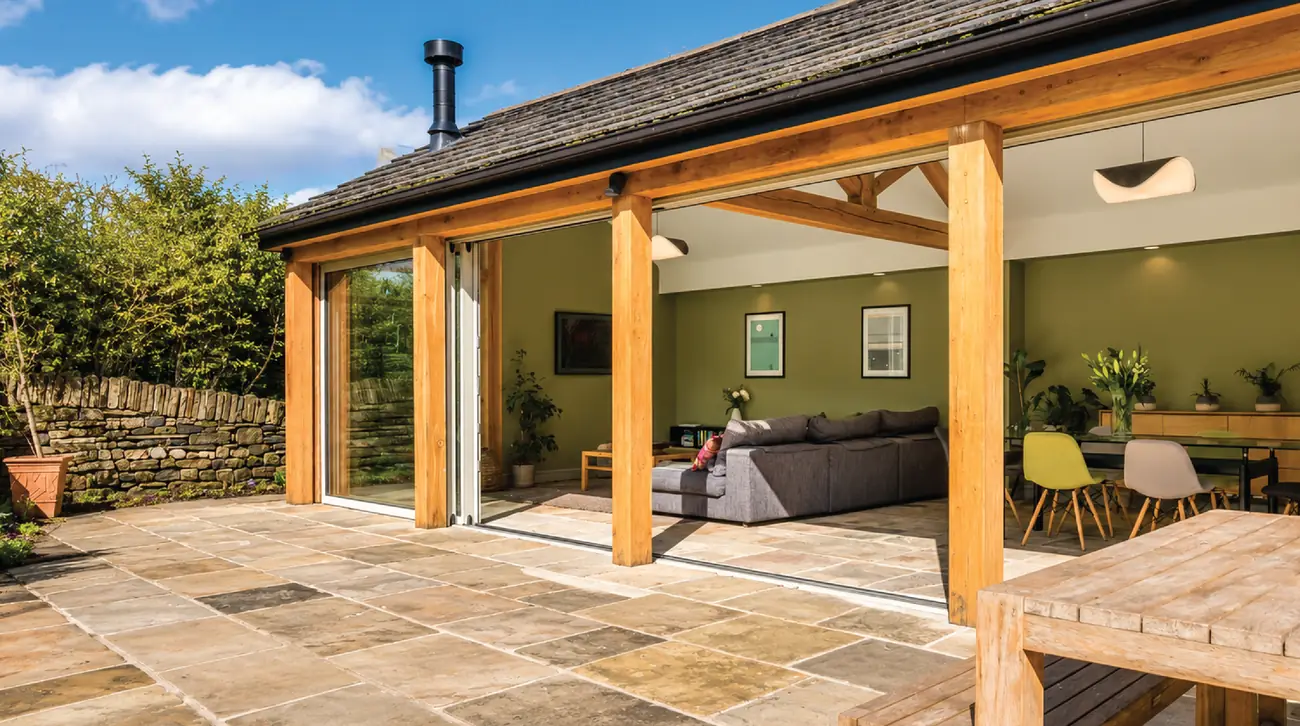 Oak-framed veranda and sliding doors along the rear elevation, opening onto a stone-flagged terrace