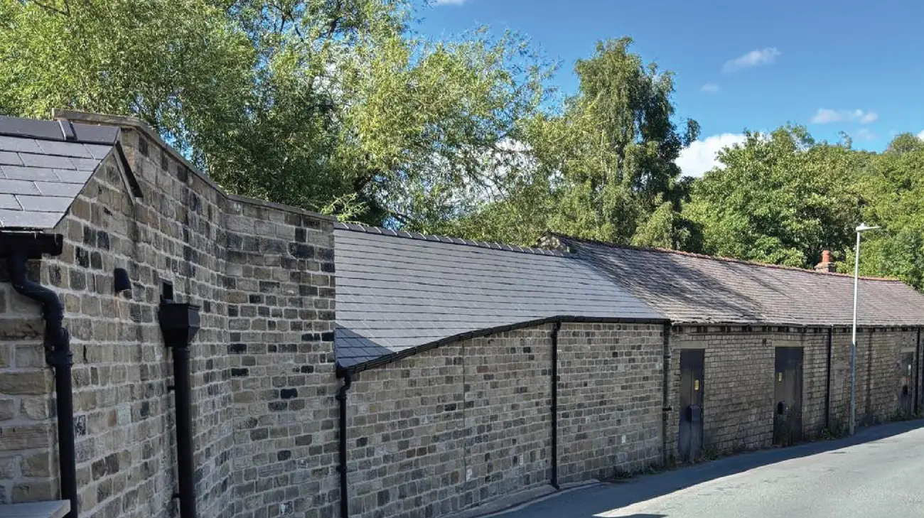Completed stone elevation with a natural slate roof and new rainwater goods