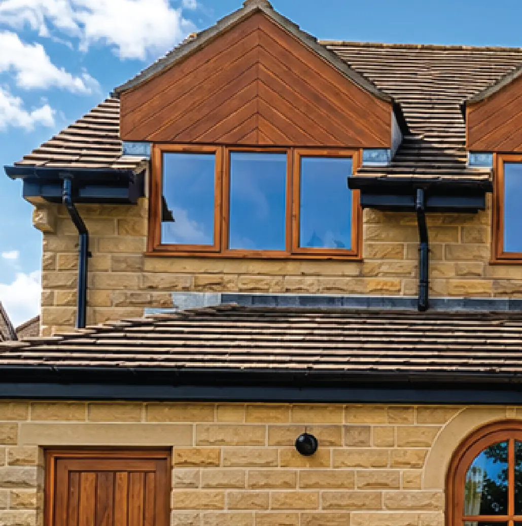 Hardwood dormer windows and a timber-clad gable on a Yorkshire stone house